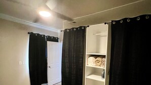 Una camera da letto con un letto, un armadio e uno scaffale con oggetti.