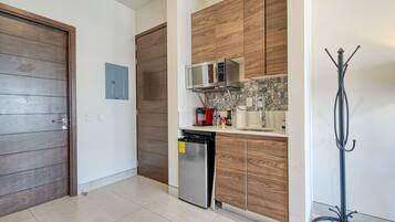 Une cuisine avec des meubles en bois, un four à micro-ondes, un lave-vaisselle et un dosseret carrelé.