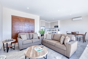 A modern living room with a sofa set, a coffee table, and a chessboard. - Stunning Oceanfront Luxury Apartment With Spacious Balcony Perfect for Families (Cabo San Lucas)