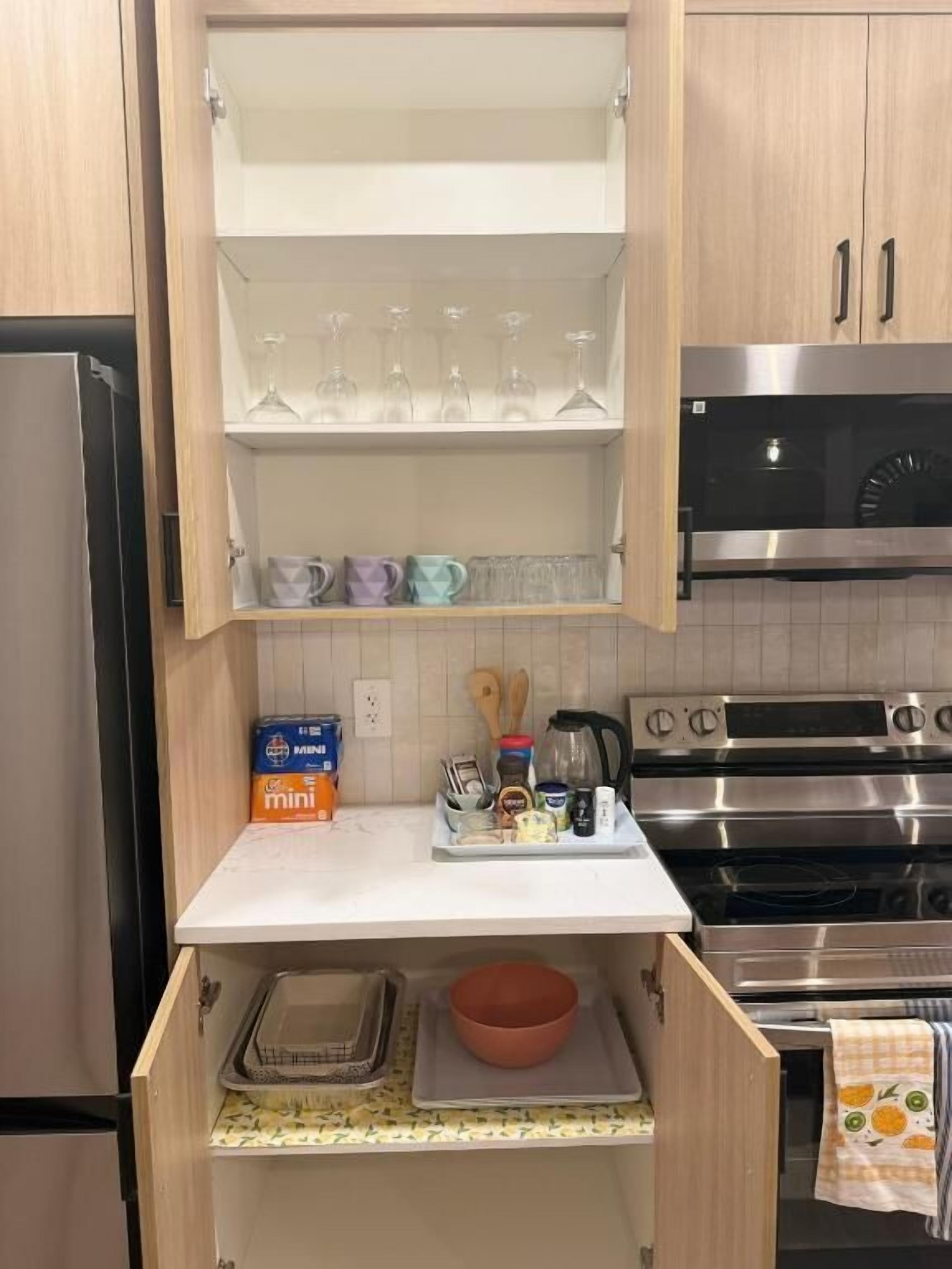 A kitchen with wooden cabinets, a stainless steel oven, and a mini fridge.