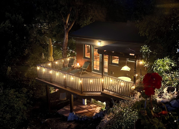 A wooden deck with outdoor seating and a glass enclosure.