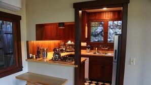 A kitchen with wooden cabinets, a stove, and a refrigerator. - Charming furnished "Tree House" in the Hollywood Hills with views and parking. (Los Angeles)