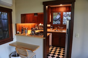 A kitchen with wooden cabinets, a stove, and a refrigerator.