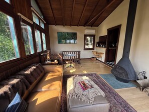 A spacious living room with a large sofa, a dining table, and a fireplace.