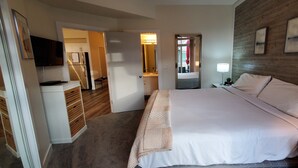 Une chambre d’hôtel avec un lit, une table de chevet, une lampe et un miroir.