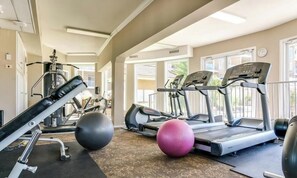 Ein Fitnessstudio mit Laufbändern, Gymbällen und Kraftgeräten.