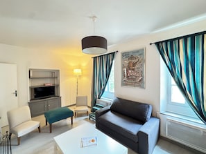 A living room with a sofa, a coffee table, a TV, a lamp, and curtains. - Vacation rental for 4 people with a pool in June, July, and September (Falga)