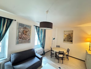 A living room with a sofa, dining table with chairs, a ceiling fan, and two posters on the walls. - Vacation rental for 4 people with a pool in June, July, and September (Falga)