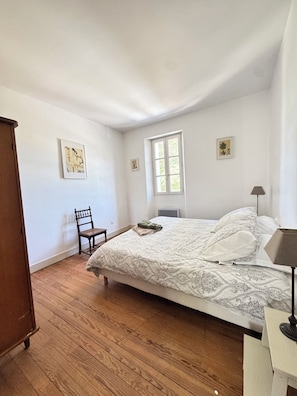 A bedroom with a bed, a chair, a window, and a lamp. - Vacation rental for 4 people with a pool in June, July, and September (Falga)