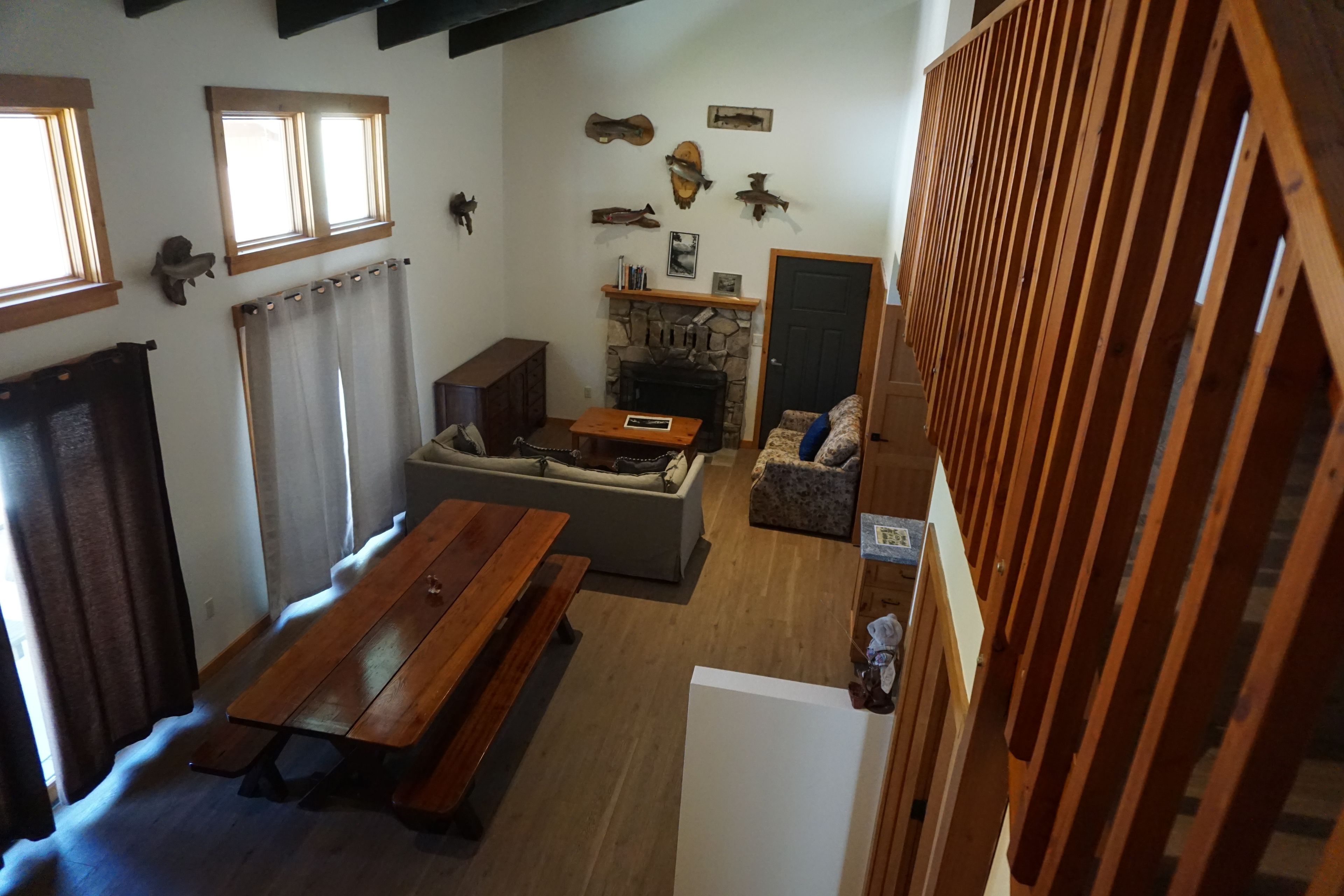 A cozy living room with a fireplace, a sofa, a wooden table, and a dining table.