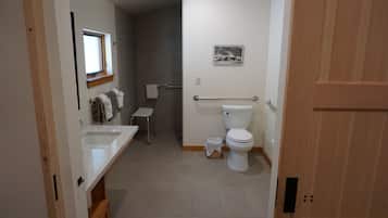 A bathroom with a toilet, sink, and shower area.