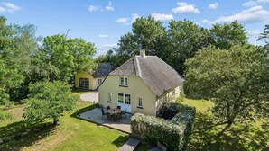 A two-story house with a patio, a small deck, and a well-maintained lawn. - 4 Star Holiday Home in Harpelunde (Harpelunde)