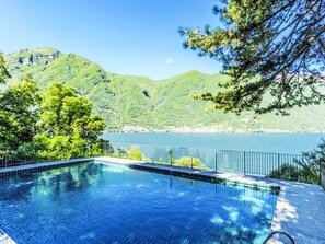 Ein Schwimmbad mit Blick auf einen See und Berge.