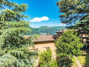 A hillside villa with terracotta roofs, surrounded by lush greenery and mountains in the background. - Casa Odri by Interhome (Nesso)