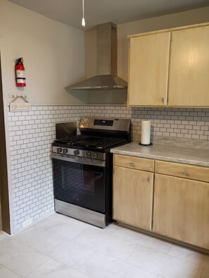 A kitchen with a stainless steel stove, oven, and wooden cabinets.