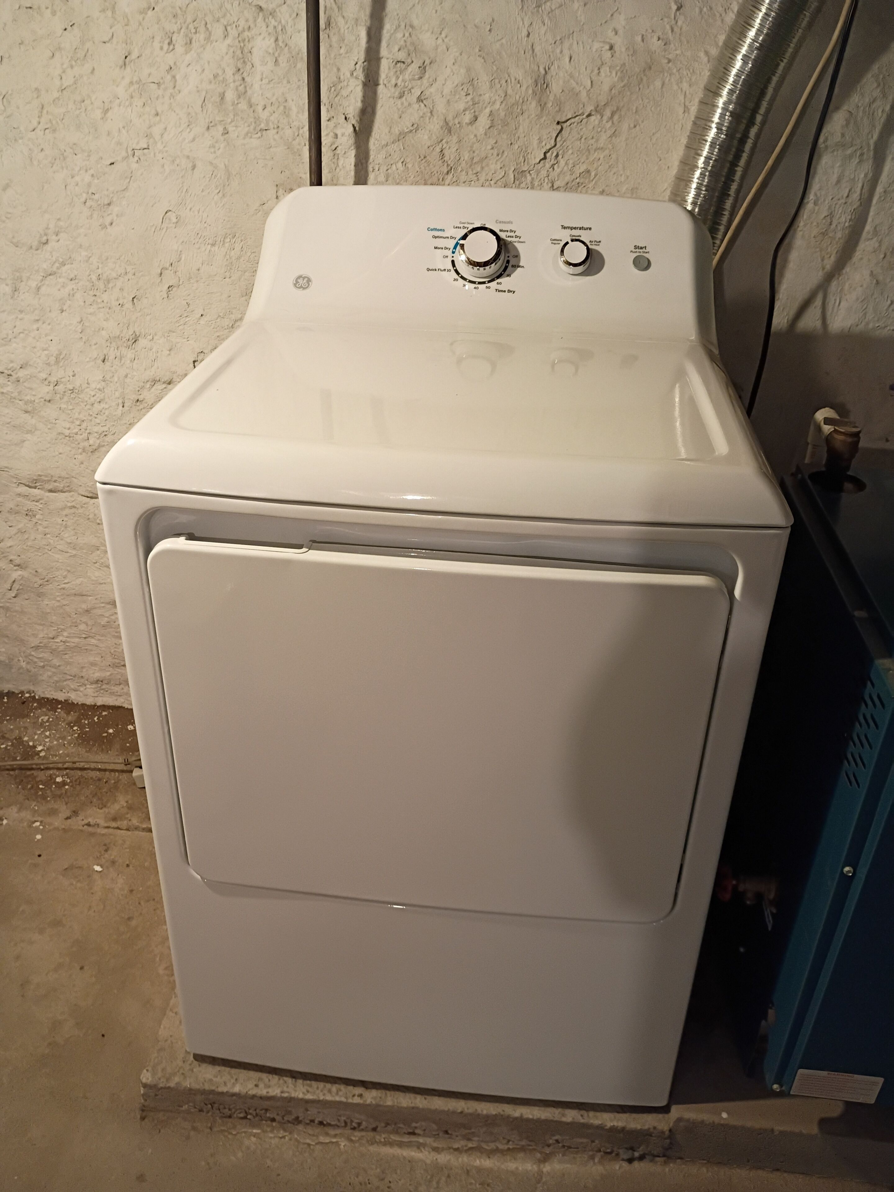 A front-loading washing machine with control knobs and a start button.