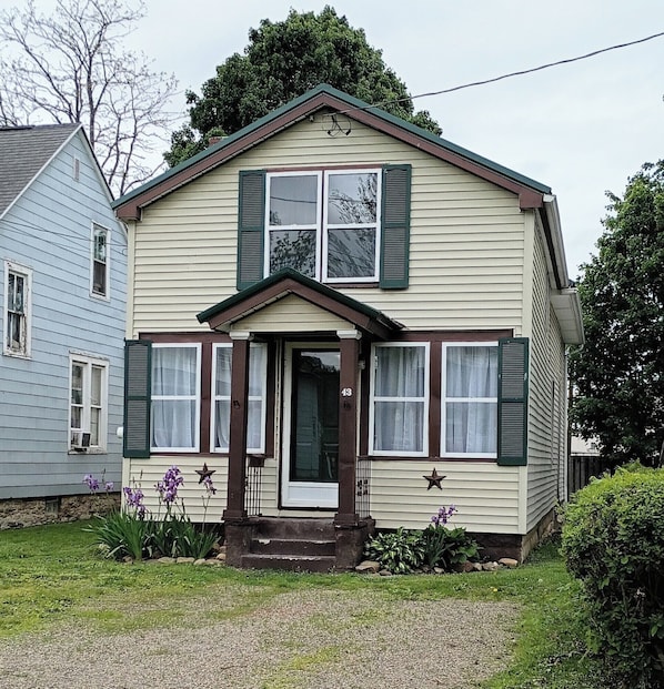 A two-story house with a front porch, a small garden, and a number '43' on the door.