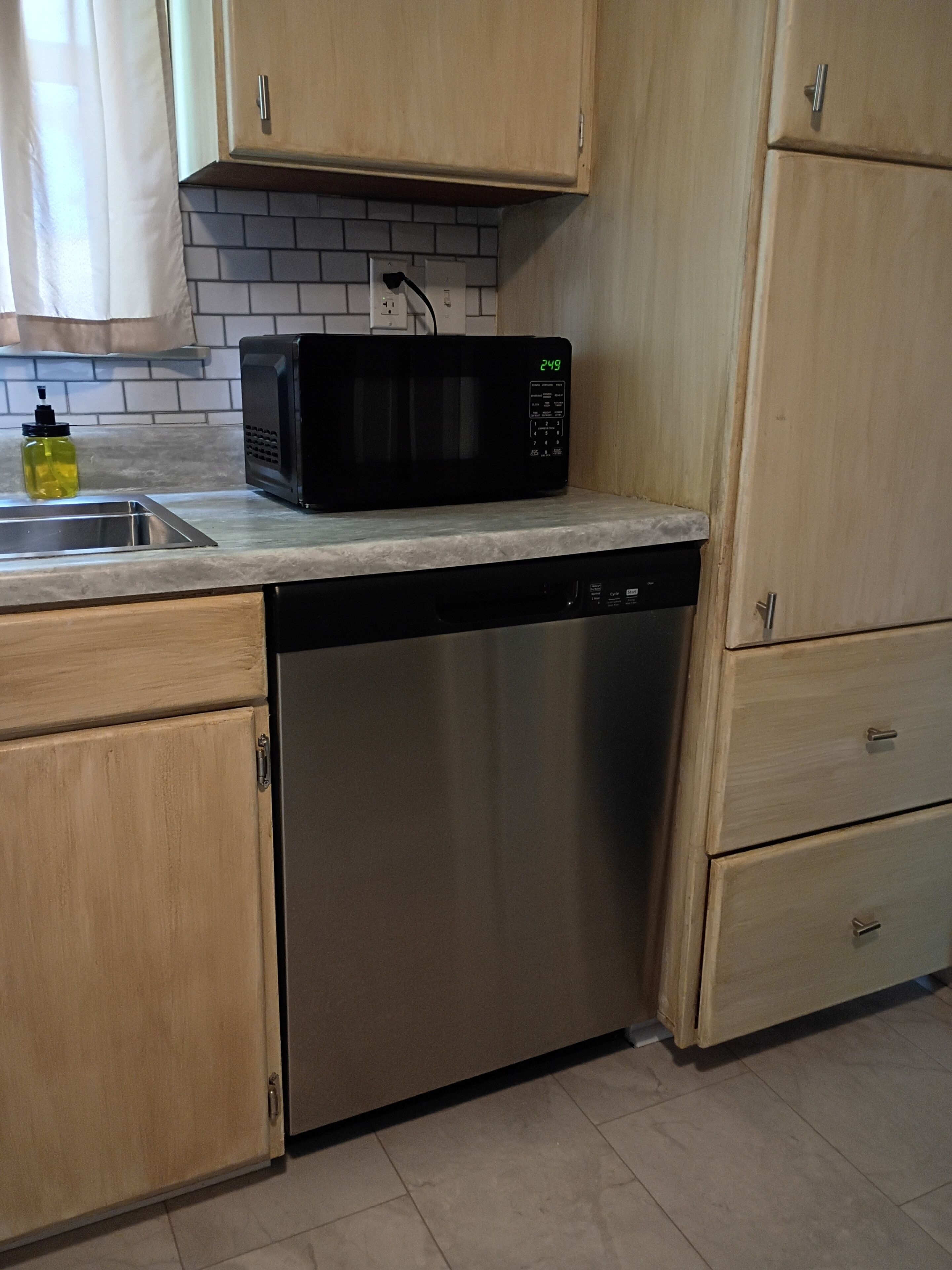 Una cocina equipada con lavavajillas, microondas y armarios de madera.