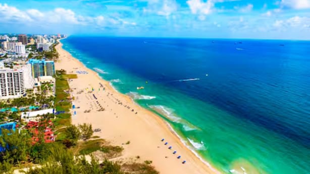A coastal cityscape with a beach, ocean, and high-rise buildings. - Chic Boho Paradise: Las Olas (Oakland Park)