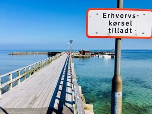 Un muelle se adentra en aguas tranquilas bajo un cielo despejado.