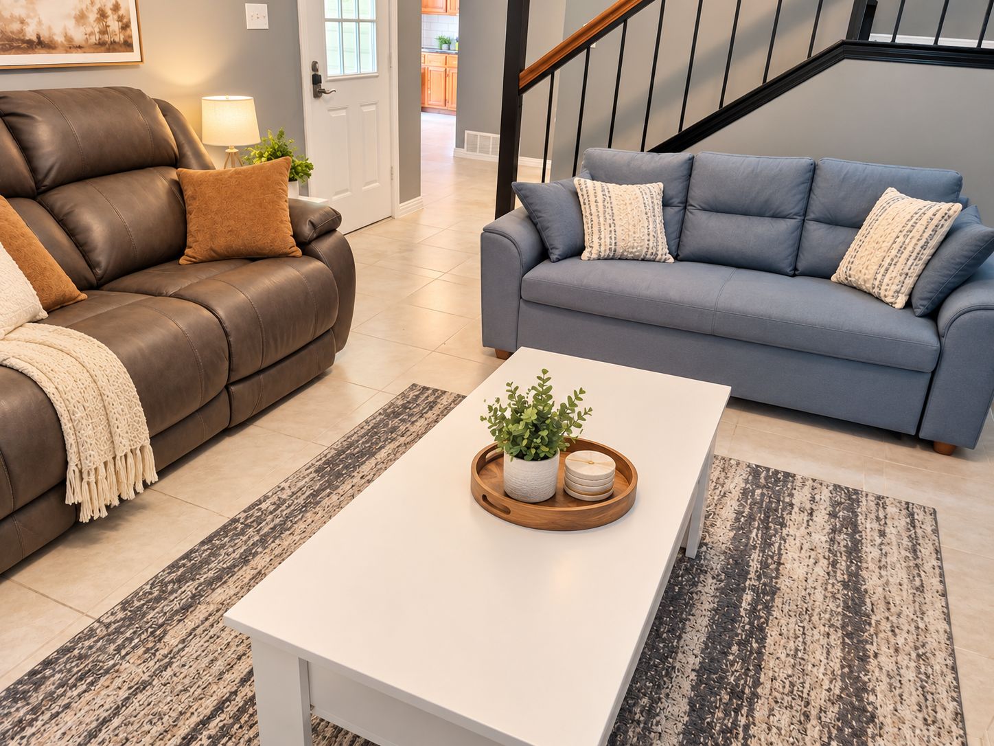 A living room with two sofas, a coffee table, and a staircase.