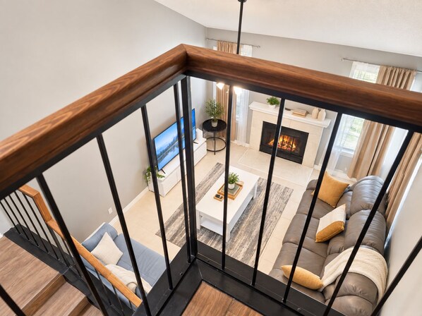 Una sala moderna con chimenea, un sofá y una televisión.