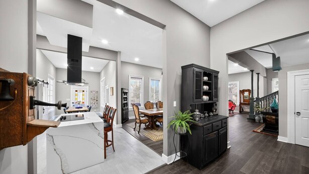 A spacious living area with a kitchen, dining room, and a staircase leading to another level. - Two Dining Tables · Sleeps 14 · 7BR, 4 Baths (Fuquay-Varina)