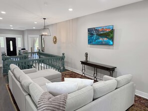 A living room with a sofa, a console table, and a painting on the wall.