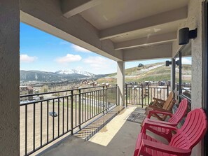 Ein Balkon mit Blick auf eine Berglandschaft, einem Geländer und einigen Stühlen.
