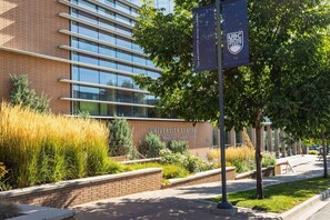 A university building with a modern glass facade, a brick lower section, and a sign indicating it's the University Centre. - 2BR | Pool, Hot Tub, Golf, UBC & Airport (Kelowna)