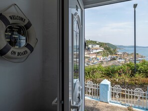 A view from inside a boat with a 'Welcome On Board' sign, a coastal town with buildings and a sea view. - Smugglers View by Interhome (Mevagissey)