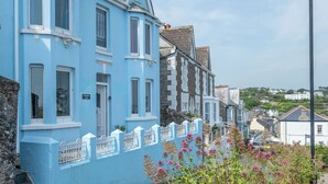 Una hilera de casas azules con barandillas blancas y una farola.
