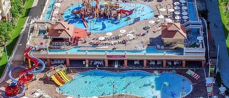 Un hôtel doté d’une grande piscine, de toboggans aquatiques et d’un espace plage avec des chaises longues.