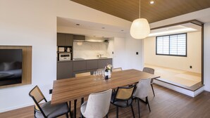 Un comedor moderno con una mesa de madera, sillas e iluminación colgante.