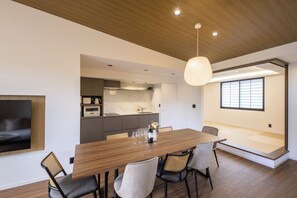 Un comedor moderno con una mesa de madera, sillas e iluminación colgante.