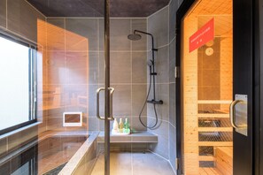 Una ducha moderna con puerta de cristal, un banco de madera y una pantalla digital.
