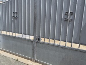 Ein schmiedeeisernes Tor mit vertikalen Streben und Verzierungen.