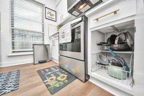 Eine Küche mit Einbauofen, Kühlschrank und Geschirrgestell.