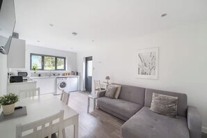 A modern apartment with a kitchen, dining area, and living room. - Lymington 1-Bed Apt, Sleeps 3 with Parking (Lymington)