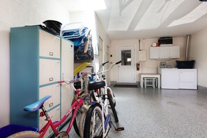 Una habitación con kitchenette, una bicicleta y un armario azul.