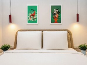 A bedroom with a bed, two wall-mounted artworks, bedside tables with plants, and pendant lights. - Gorgeous 3 Bedroom Apartment At Monnas Suite (Beyoglu)