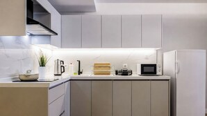 A modern kitchen with a built-in microwave, a coffee maker, and a refrigerator. - Gorgeous 3 Bedroom Apartment At Monnas Suite (Beyoglu)
