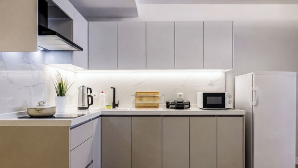 Een moderne keuken met een ingebouwde magnetron, koffiezetapparaat en koelkast.