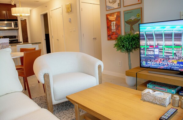 A living room with a television, a coffee table, and a sofa.