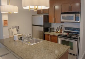 Eine Küche mit Granit-Arbeitsplatten, Edelstahlgeräten und Holzschränken.