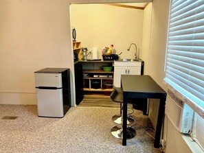 Eine kleine Küche mit Kühlschrank, Spüle und Esstisch.