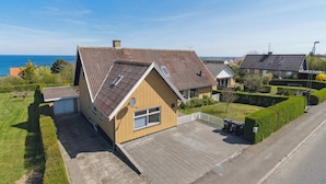 A residential house with a sloped roof, a garage, and a paved driveway. - 5 Star Holiday Home in Allinge (Allinge)