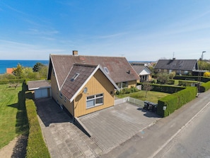 Ein Wohnhaus mit geneigtem Dach, einer Garage und einem gepflasterten Auffahrt.