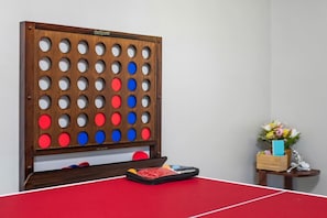 A ping pong table with a GoSports board, a small table with a vase of flowers, and a basket with a blue object. - Perfect for Families, Pet Friendly, Games Room (Ballwin)