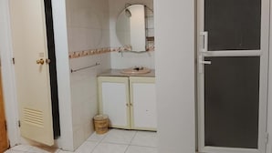 Een badkamer met toilet, wastafel, spiegel en een prullenbak.